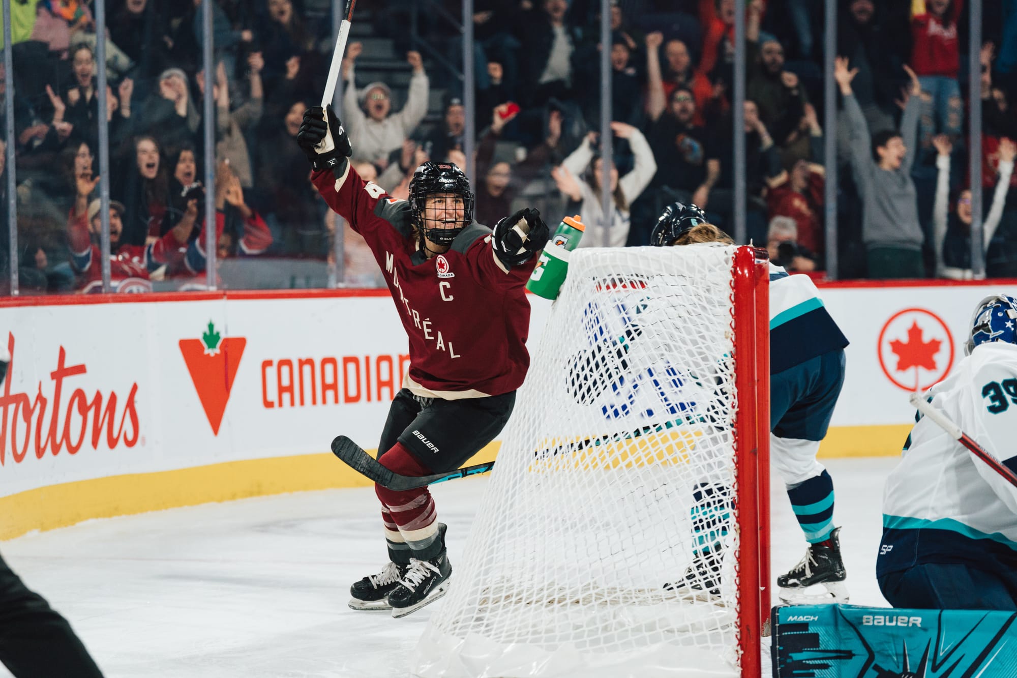 Marie-Philip Poulin, wearing her maroon home uniform, celebrates her goal against Toronto.