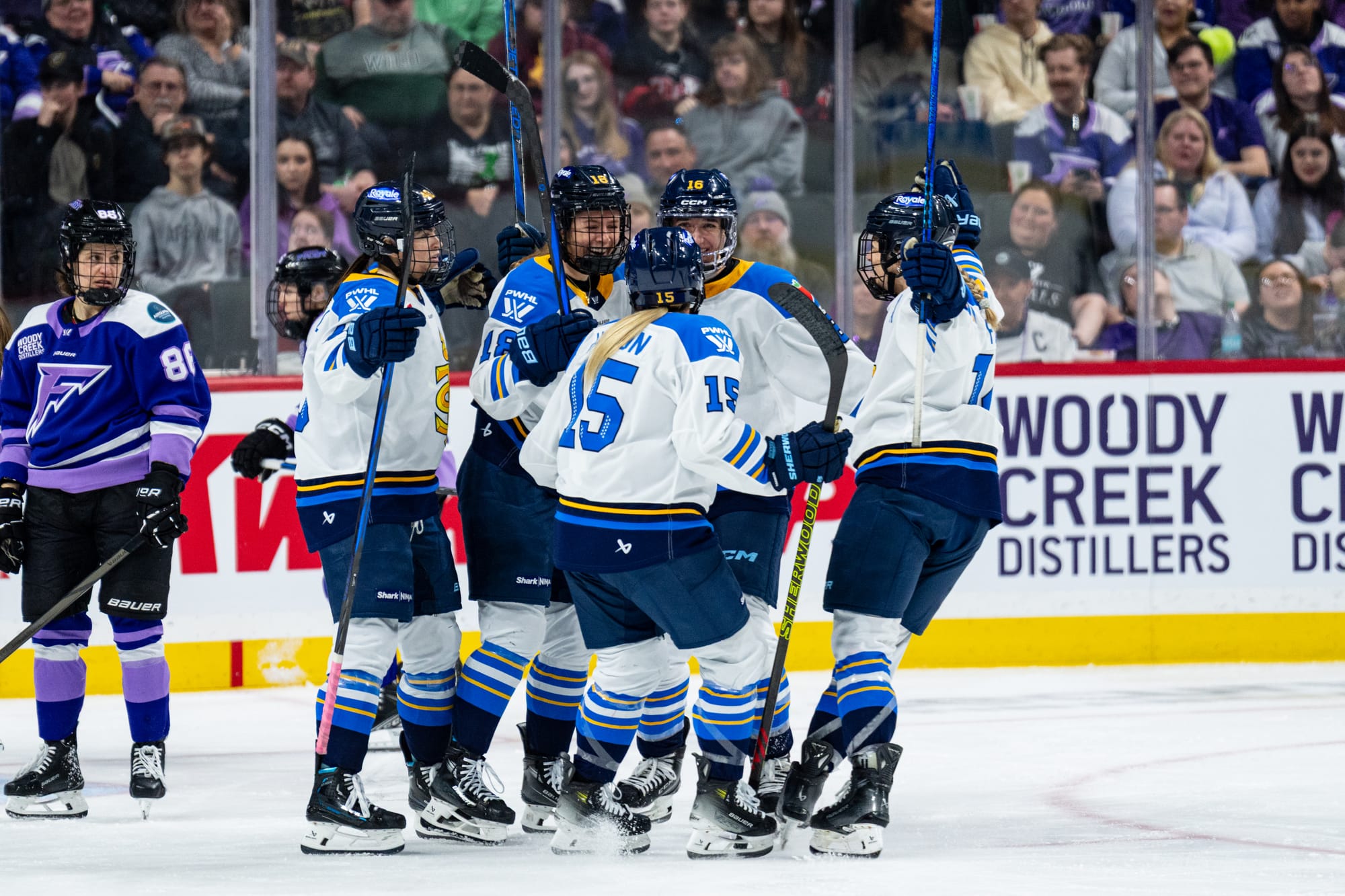 Five Toronto players celebrate a goal with a group hug. They are all wearing white away uniforms.