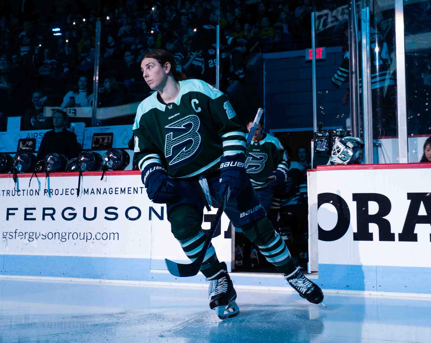 Knight looks to her right as she skates out onto the ice for the anthems at Agganis Arena. She is wearing a green home uniform.