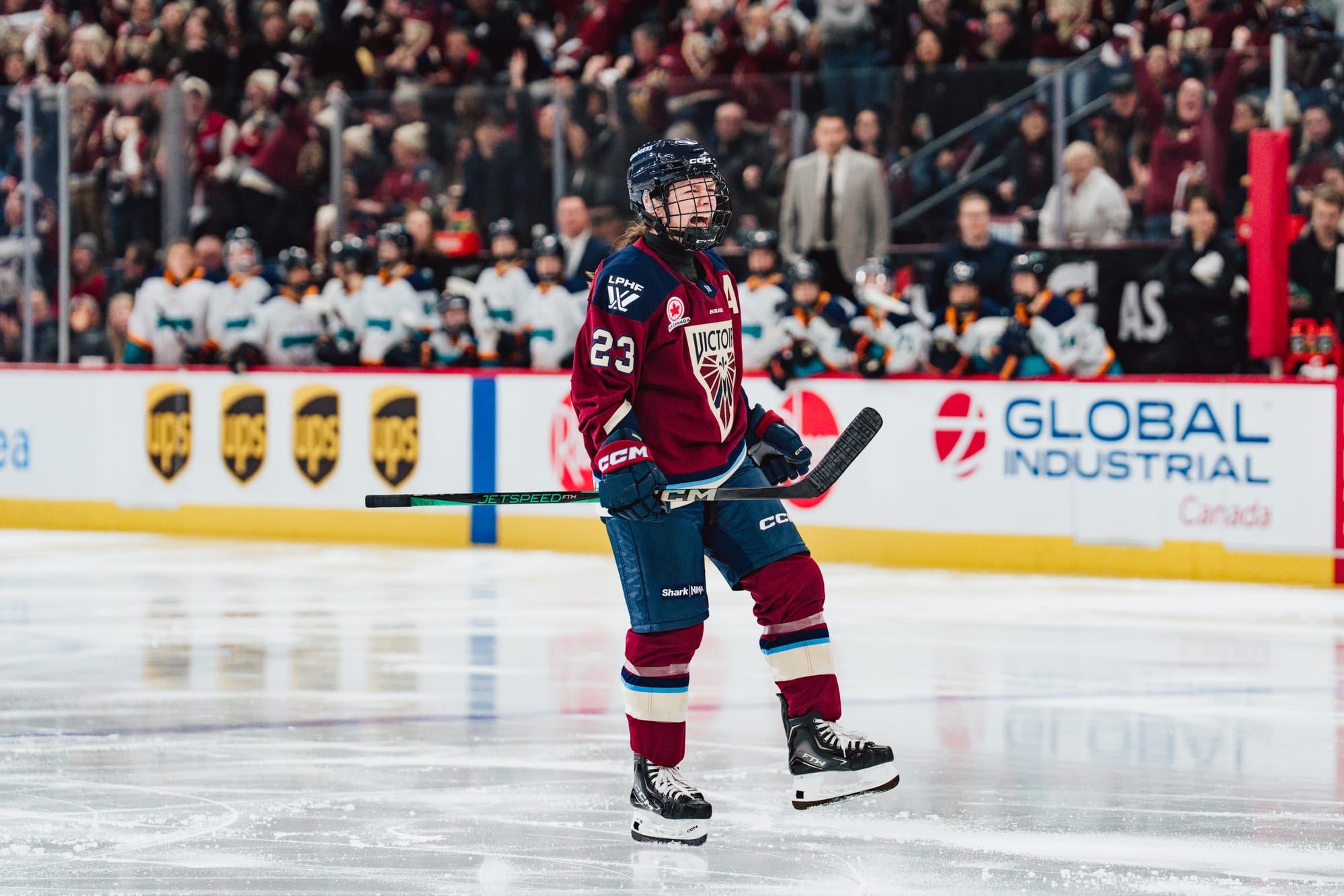 Erin Ambrose red Victoire sweater on ice cheering New York Sirens bench in the background