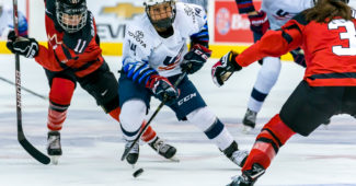 Briana Decker puck handles through Canadian defense. Photo by Matthew Raney.