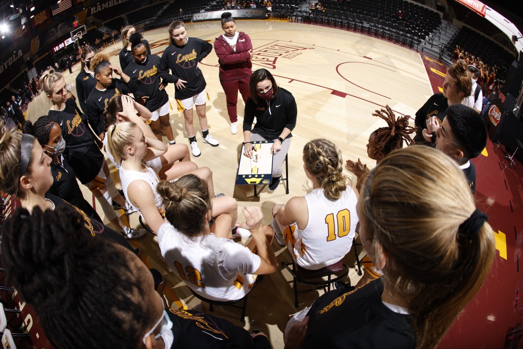 The Loyola Chicago women's basketball team huddles around head coach Kate Achter