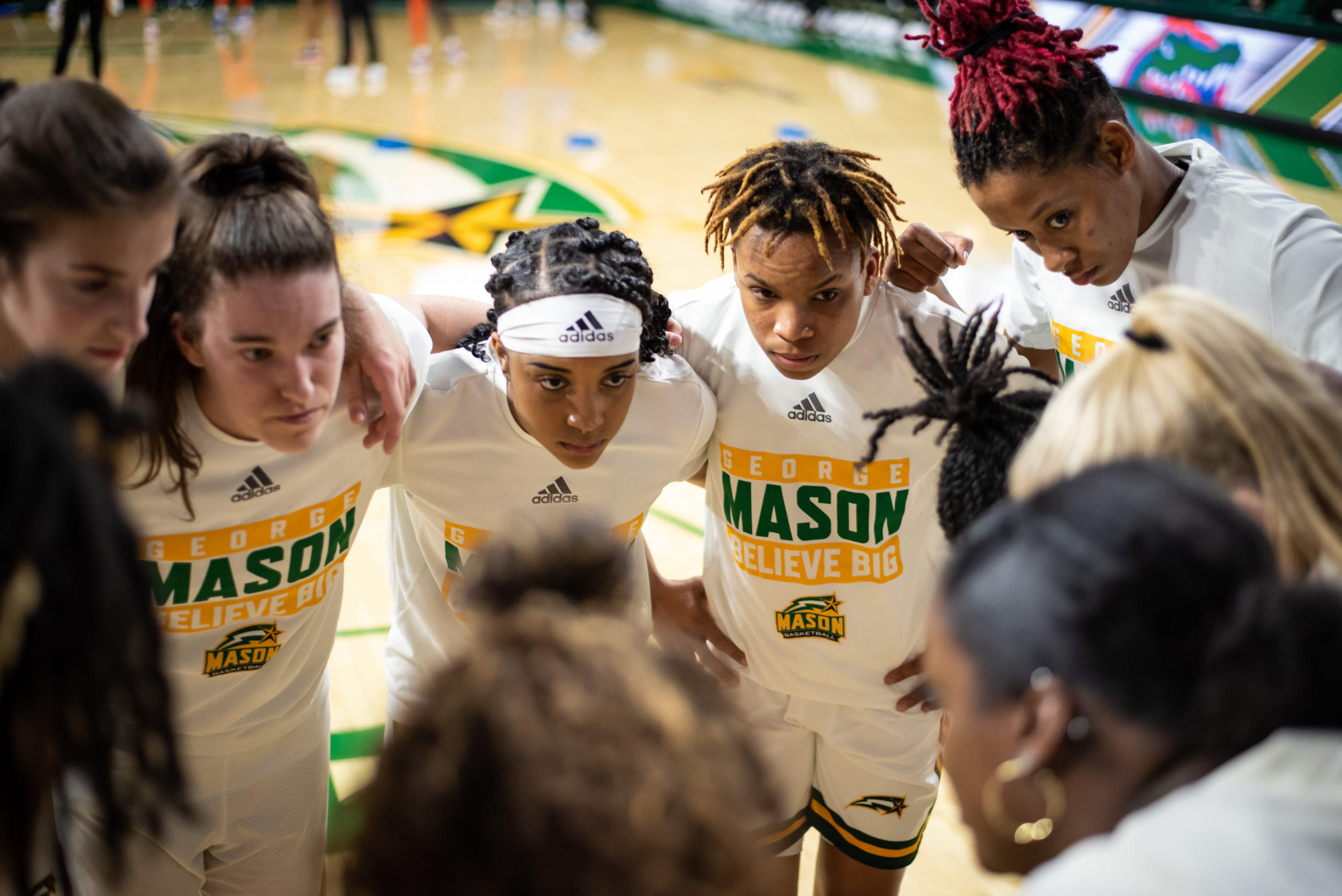 Huddle of Mason women's basketball players