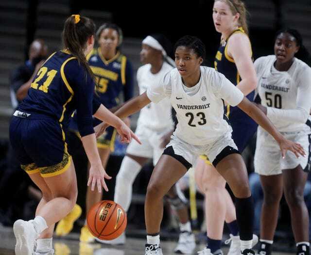 Iyana Moore stands in a defensive stance, facing an opposing ball-handler.