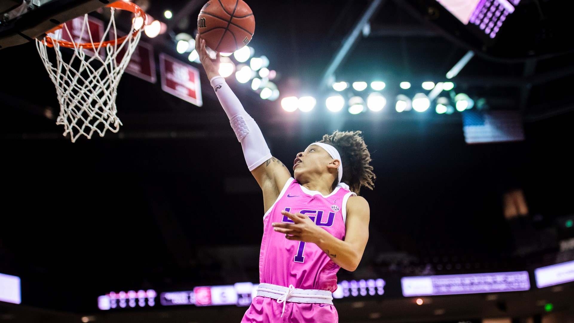 Jailin Cherry, midair, focuses on her hand as she rises to the height of the rim to lay in the ball.