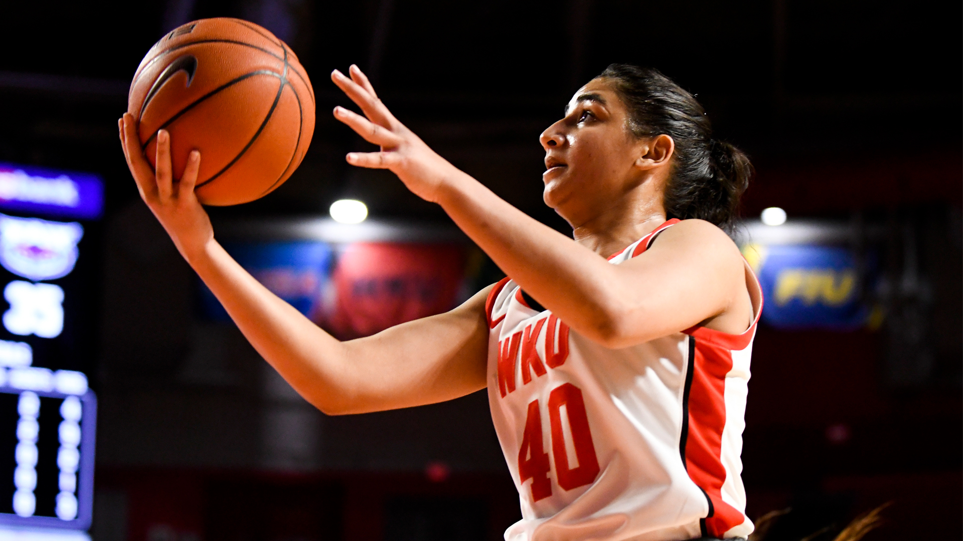 Meral Abdelgawad goes up midair for a layup, cradling the ball in her right hand while removing her guide hand.