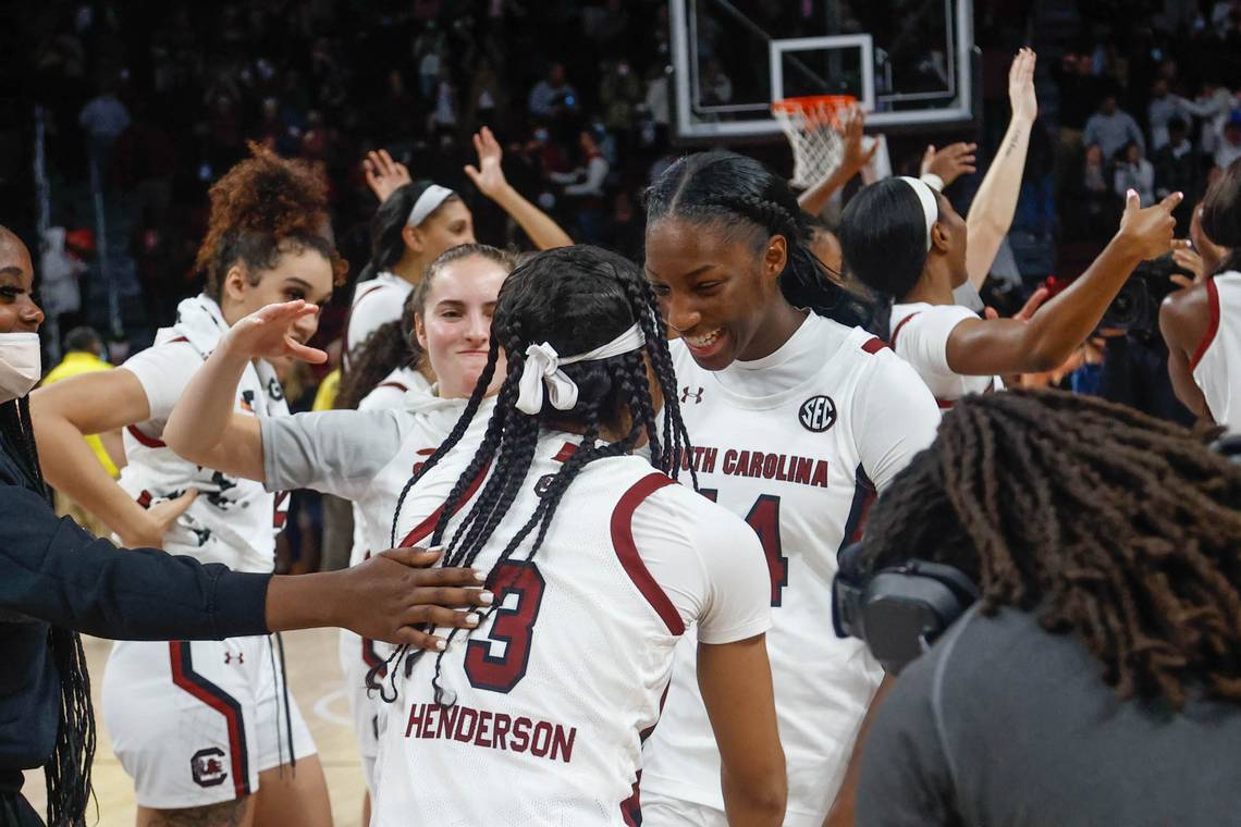 Olivia Thompson smugly comes over to dap up Destanni Henderson, who is celebrating with an overjoyed Eniya Russell while the rest of the Gamecocks celebrate in the background.