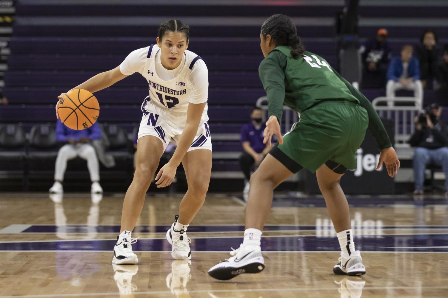 Veronica Burton sizes up her defender from beyond the arc while she holds a hang dribble.