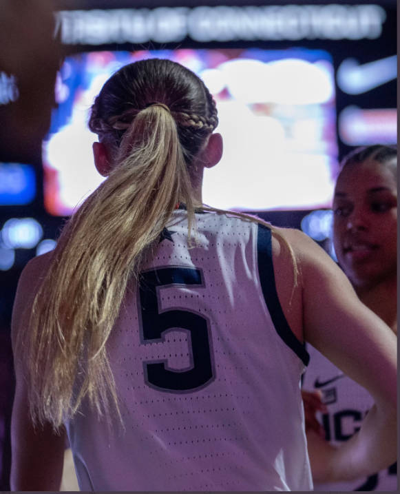 Paige Bueckers is photographed in her number five jersey while running onto the court.