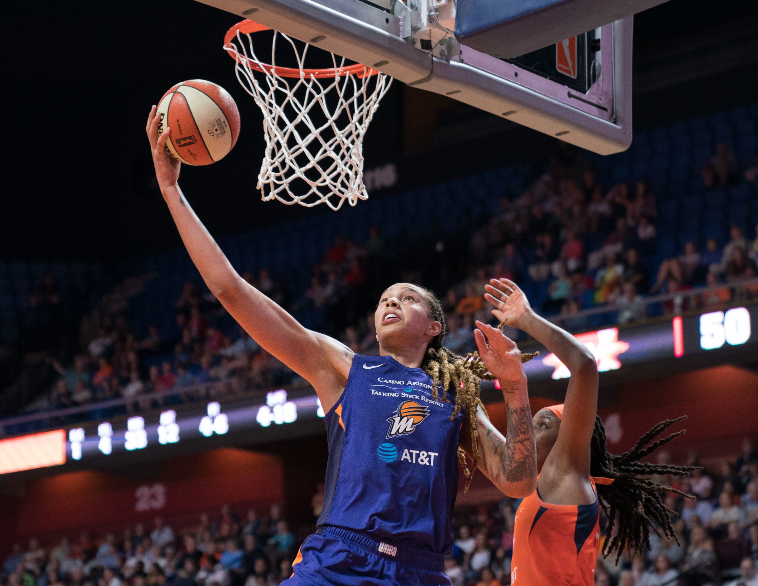 Brittney Griner soars to basket in Phoenix Mercury purple and orange uniform.