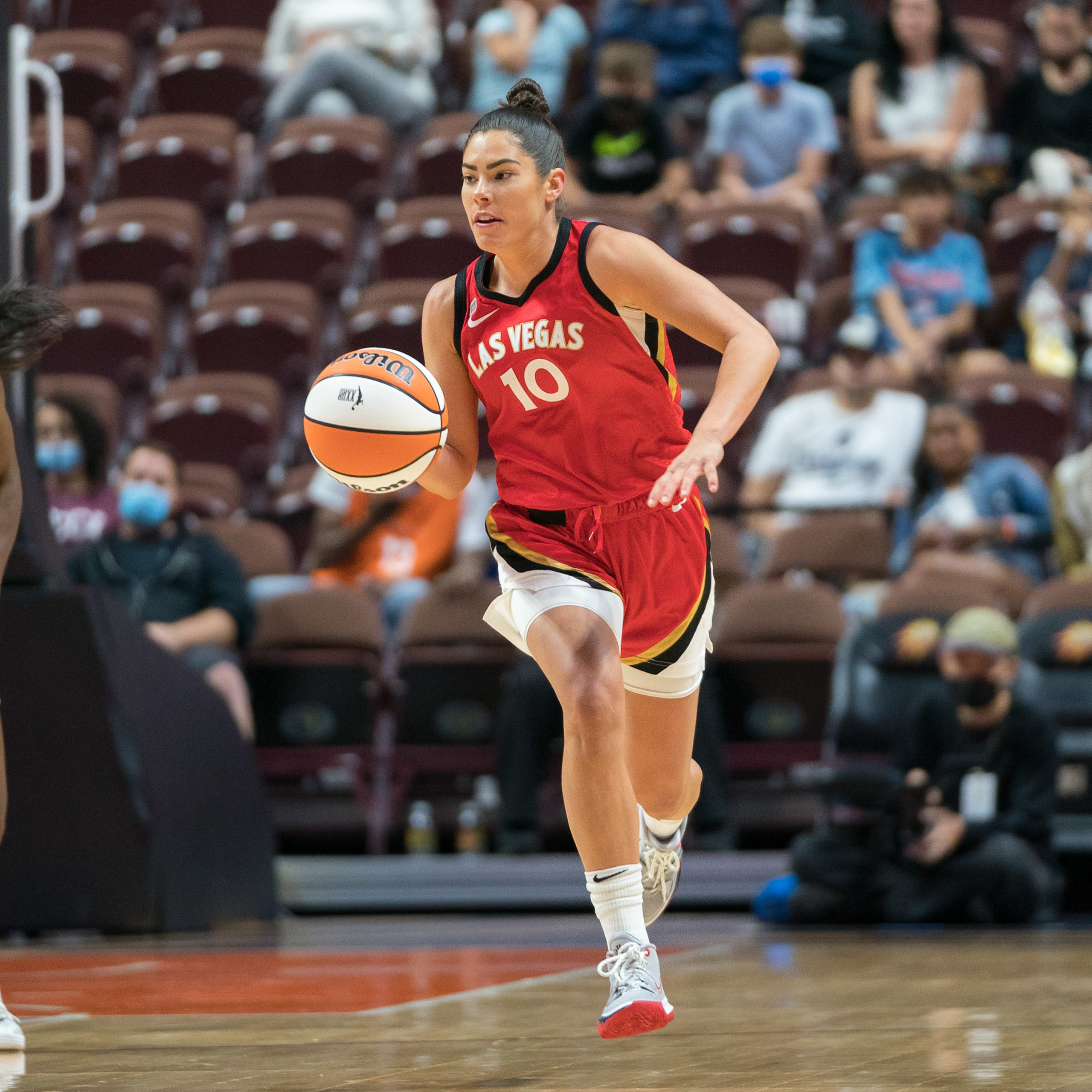 Las Vegas Aces guard Kelsey Plum dribbles the ball up the court with no defenders nearby.