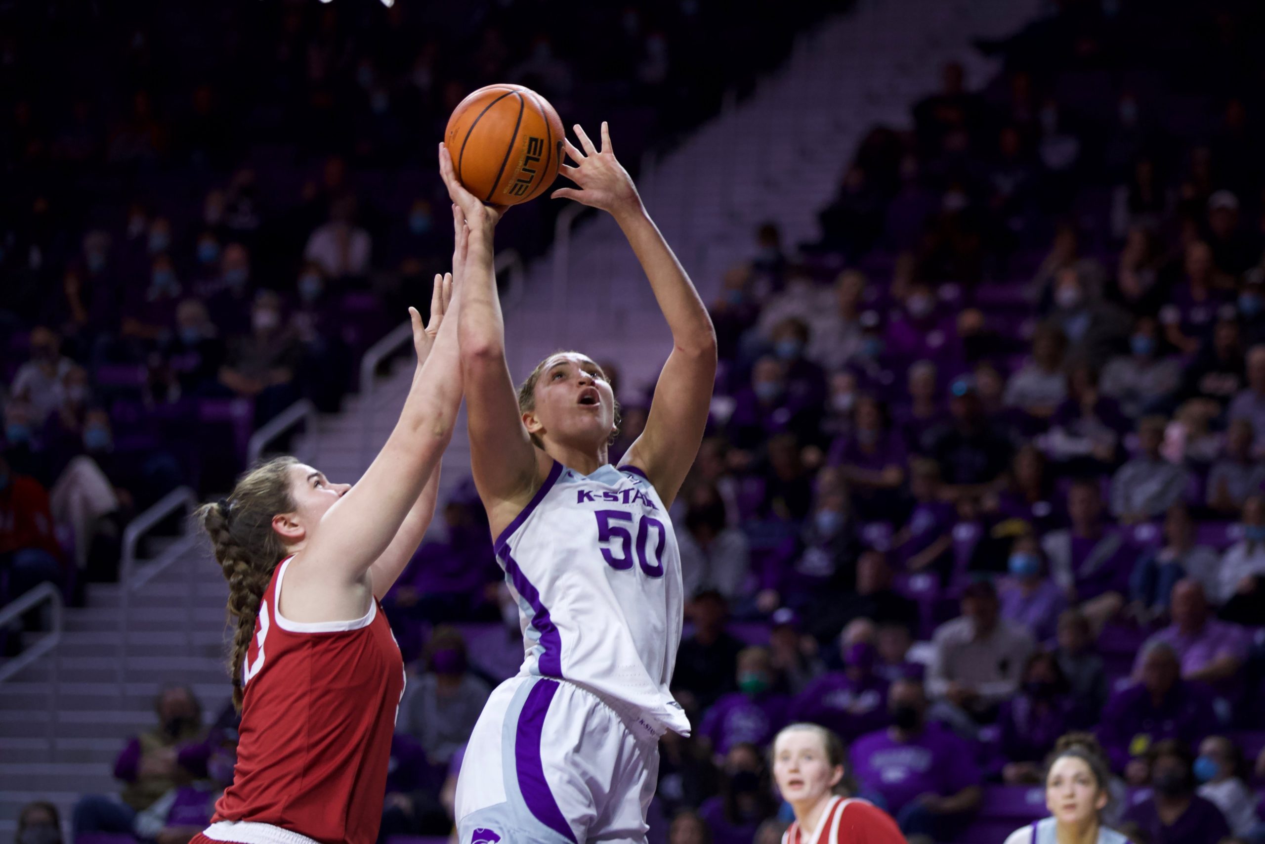 Ayoka Lee goes up to shoot a layup while a defender fouls her on her shooting wrist from behind