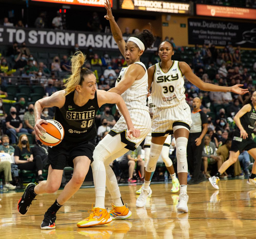 Breanna Stewart dribbles tightly around Candace Parker, while Azurá Stevens, Parker's teammate, stands behind her with her arms straight out, as if to say to Parker "what are you doing"