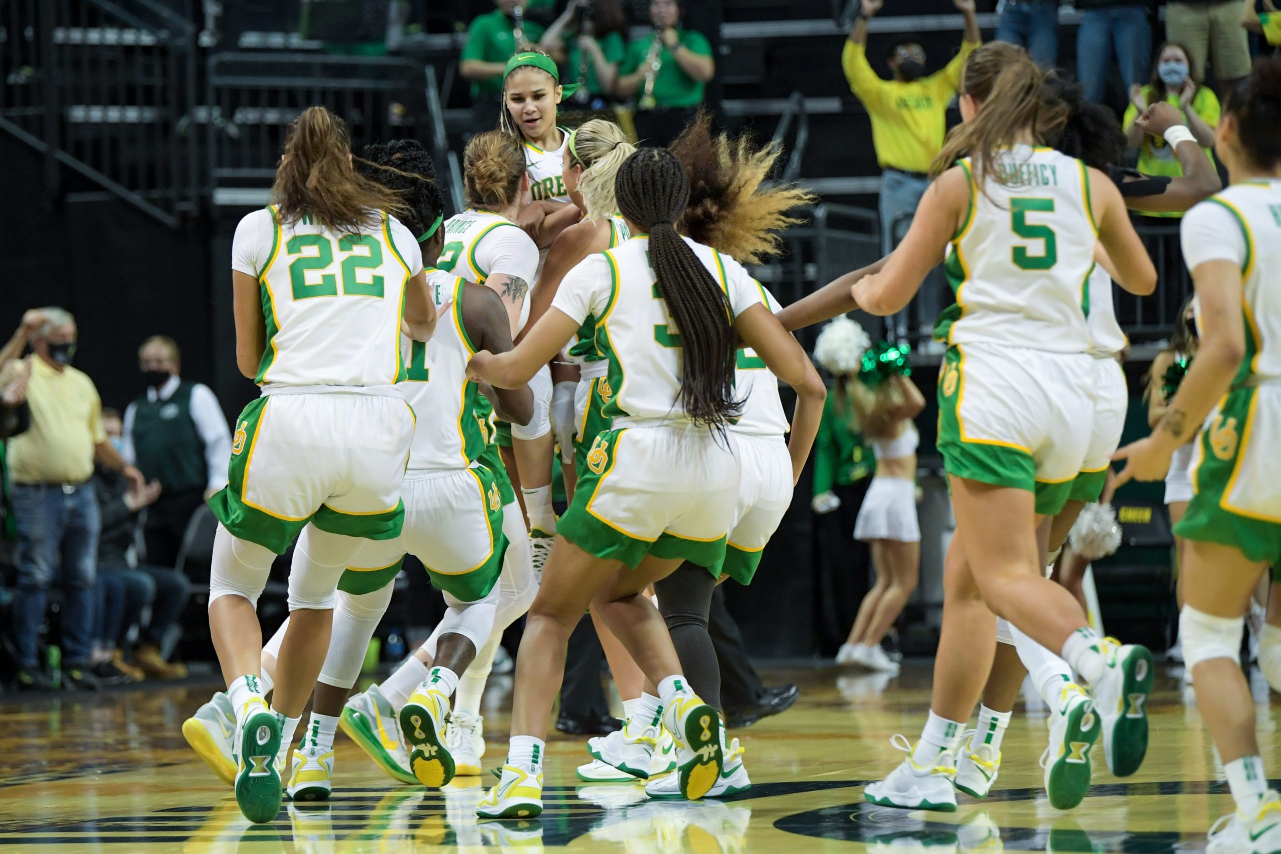 Teammates swarm Oregon's Ednyia Rogers while she is hoisted into the air in celebration