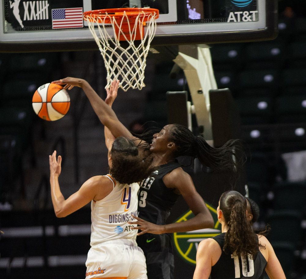 Ezi Magbegor blocks a Skylar Diggins-Smith layup attempt from over Diggins-Smith's shoulder, with Sue Bird watching out-of-focus in the foreground