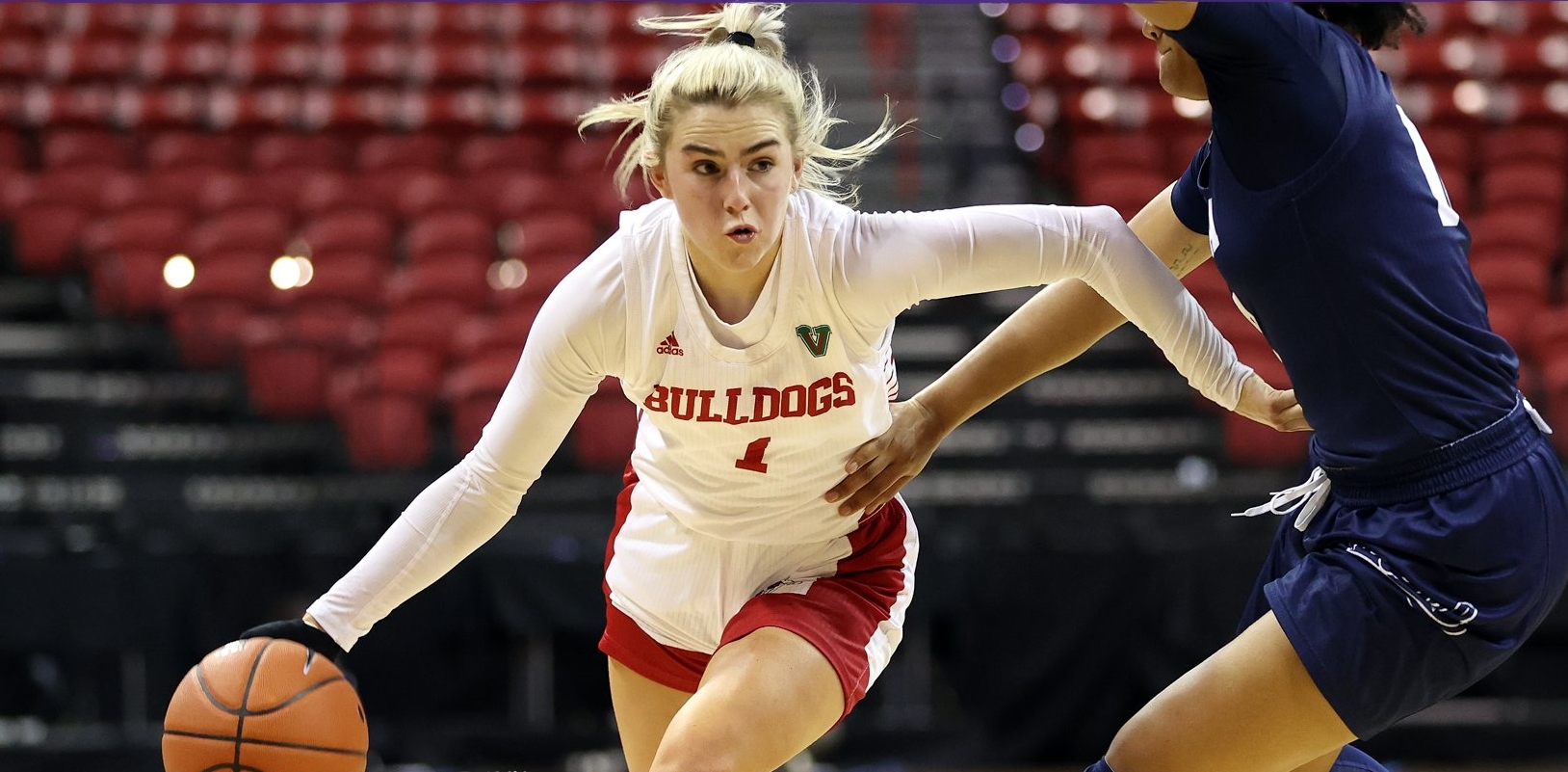 Haley Cavinder puts her head down and dribbles around a sideways-facing defender