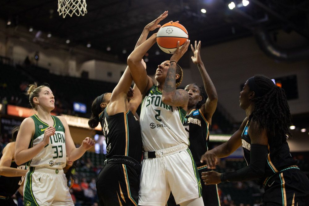 Mercedes Russell goes up in traffic for a layup, Betnijah Laney swinging onto her arm and Natasha Howard trying to block from behind