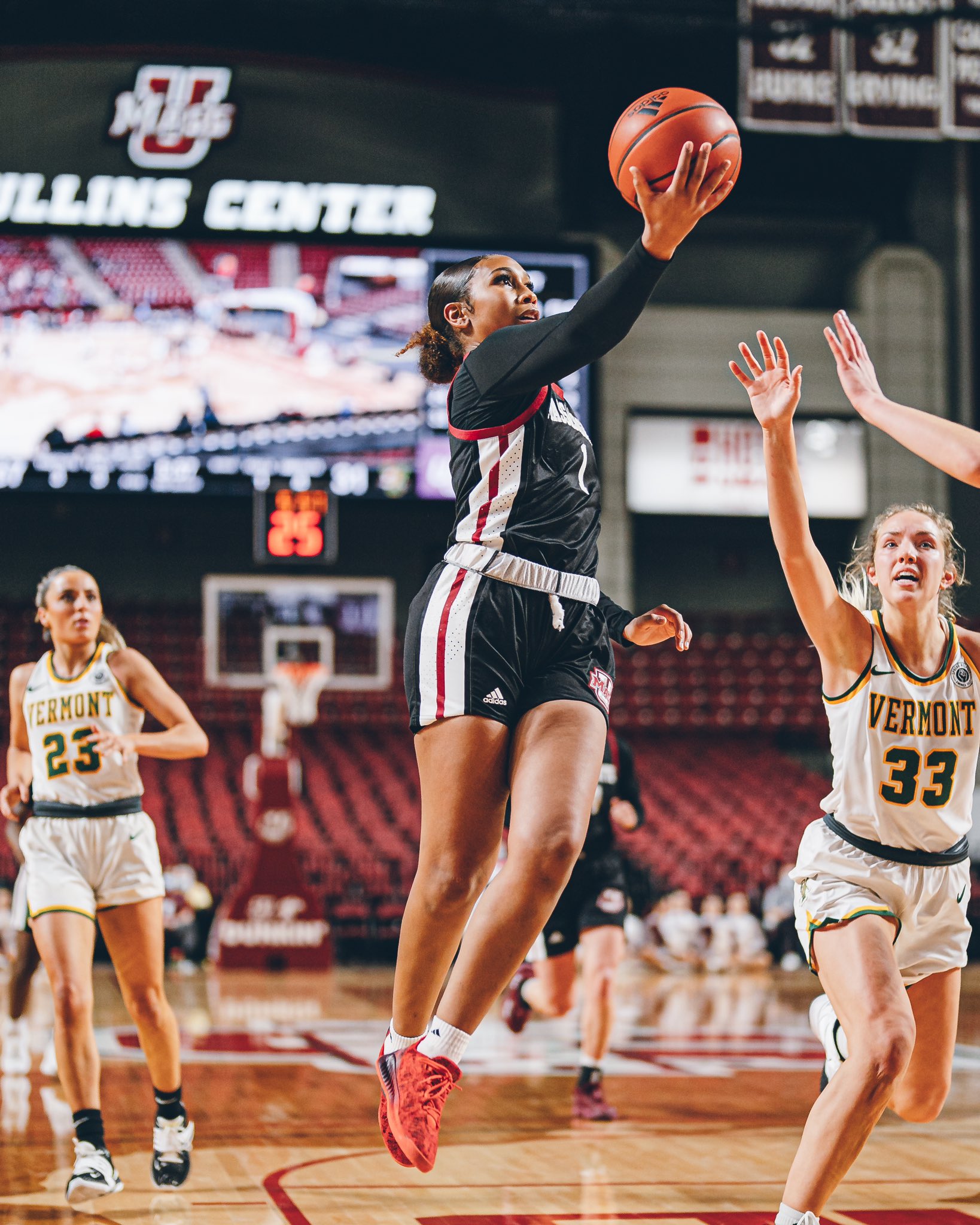 Sydney Taylor twists her body to hit a layup as a pair of defenders futilely reach out to attempt to contest the shot
