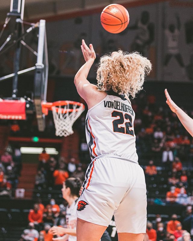 looking from behind her, Talia von Oelhoffen holds her release as a three-point shot travels towards the rim from the corner