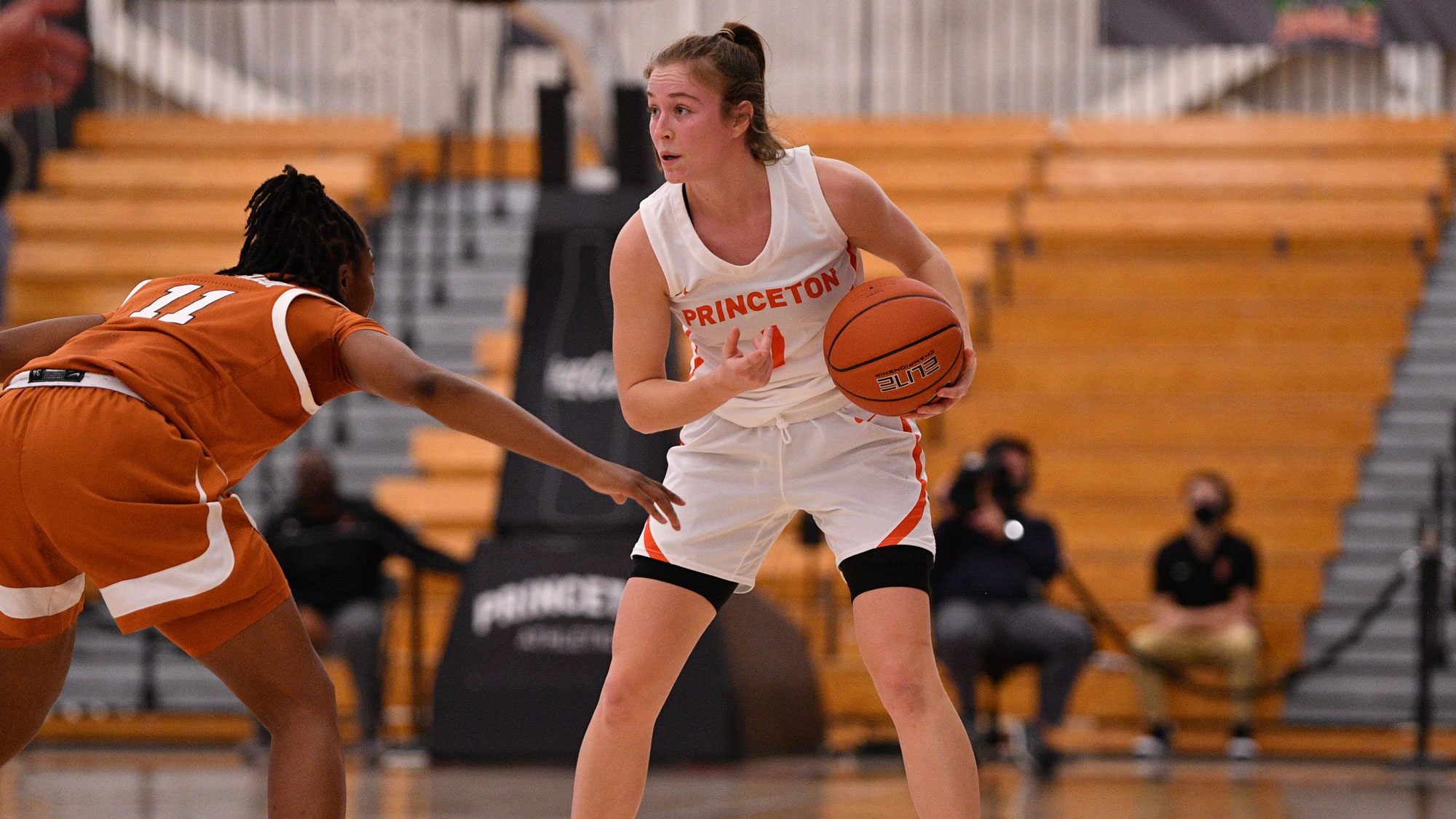 Abby Meyers cradles the ball in front of a defender while directing a teammate