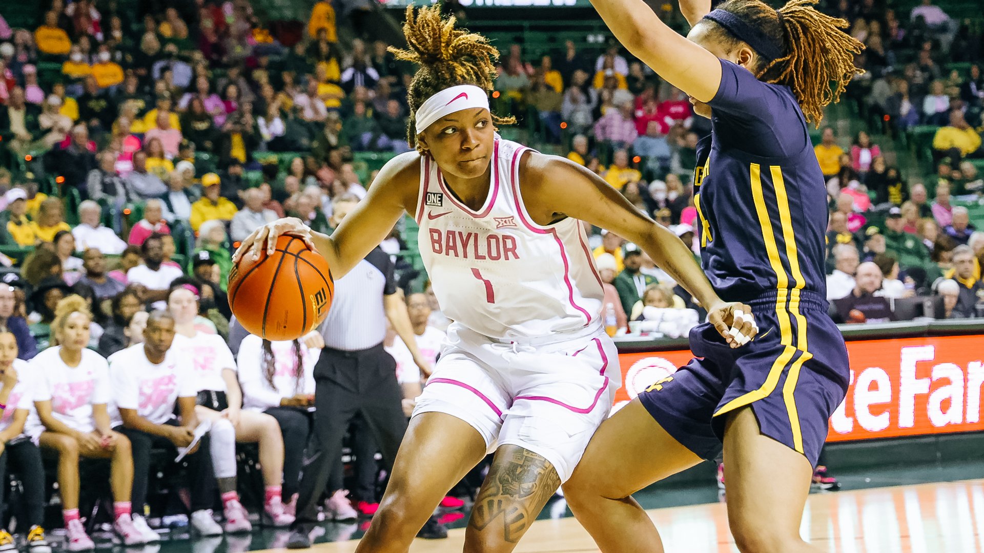 NaLyssa Smith looks across the baseline as she dribbles around a defender