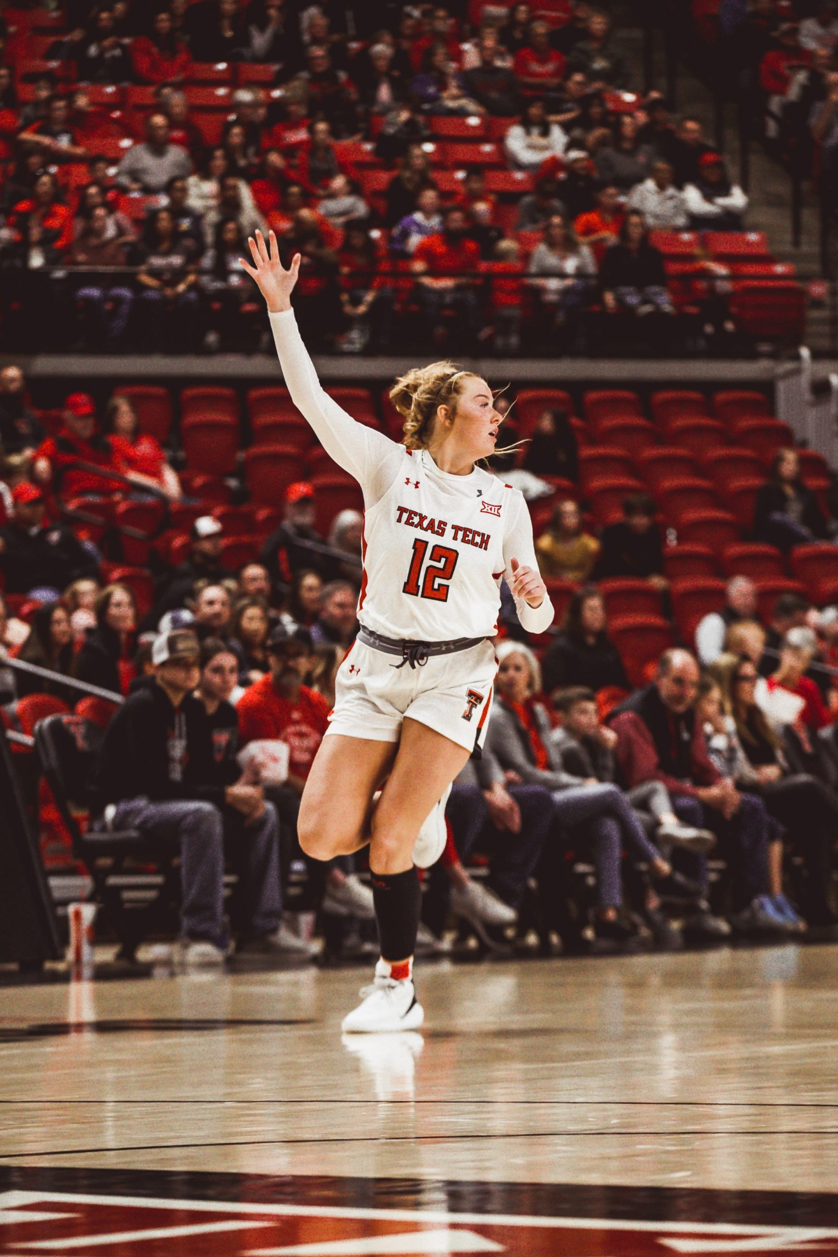 Vivian Gray stands alone, moving towards the midcourt, looking upcout and motioning her arm up to call for the ball