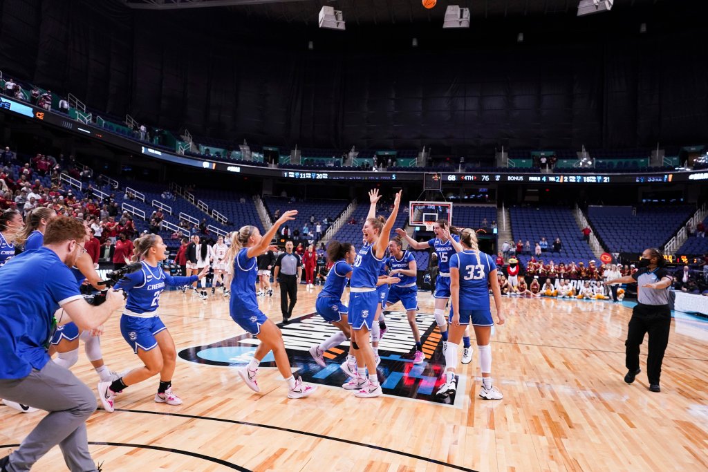 The Creighton Bluejays sprint out to meet in celebration at halfcourt.