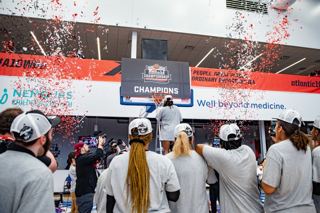 UMass takes in the sight of the confetti as Destiney Philoxy prepares to cut down the net.