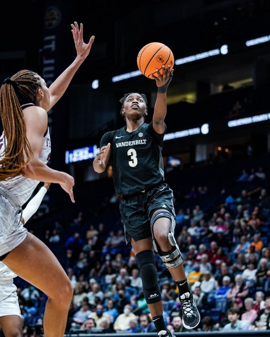 Jordyn Cambridge rises through midair to layup the ball while a defender tries to close out from the side
