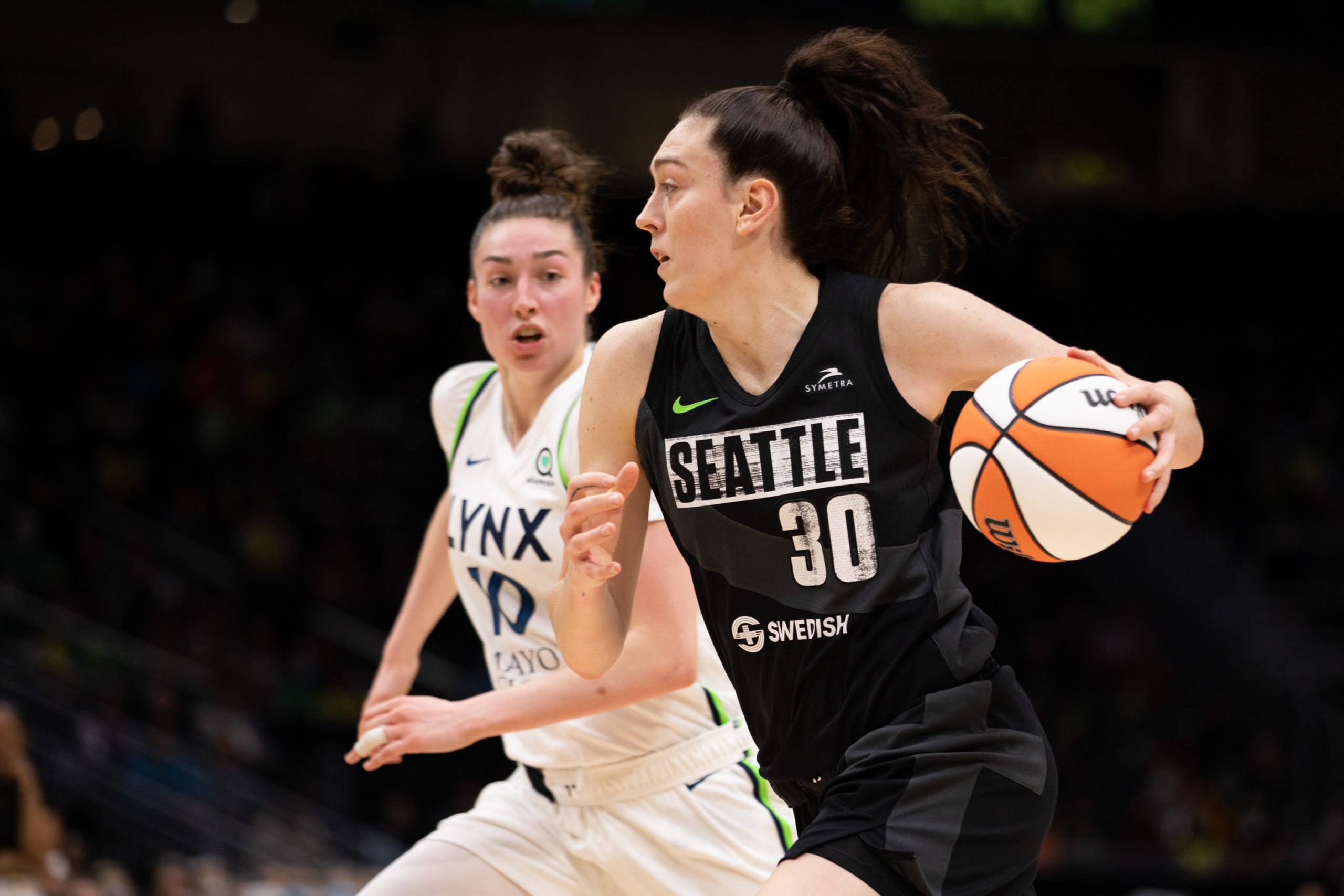 Seattle Storm big wing Breanna Stewart controls the ball as she dribbles around Minnesota Lynx combo forward Jessica Shepard