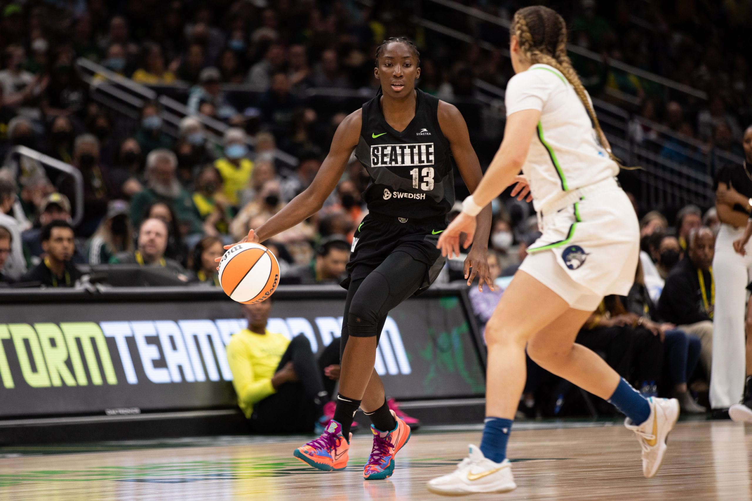 Seattle Storm big Ezi Magbegor dribbles up the court while a Minnesota Lynx defender hangs nearby