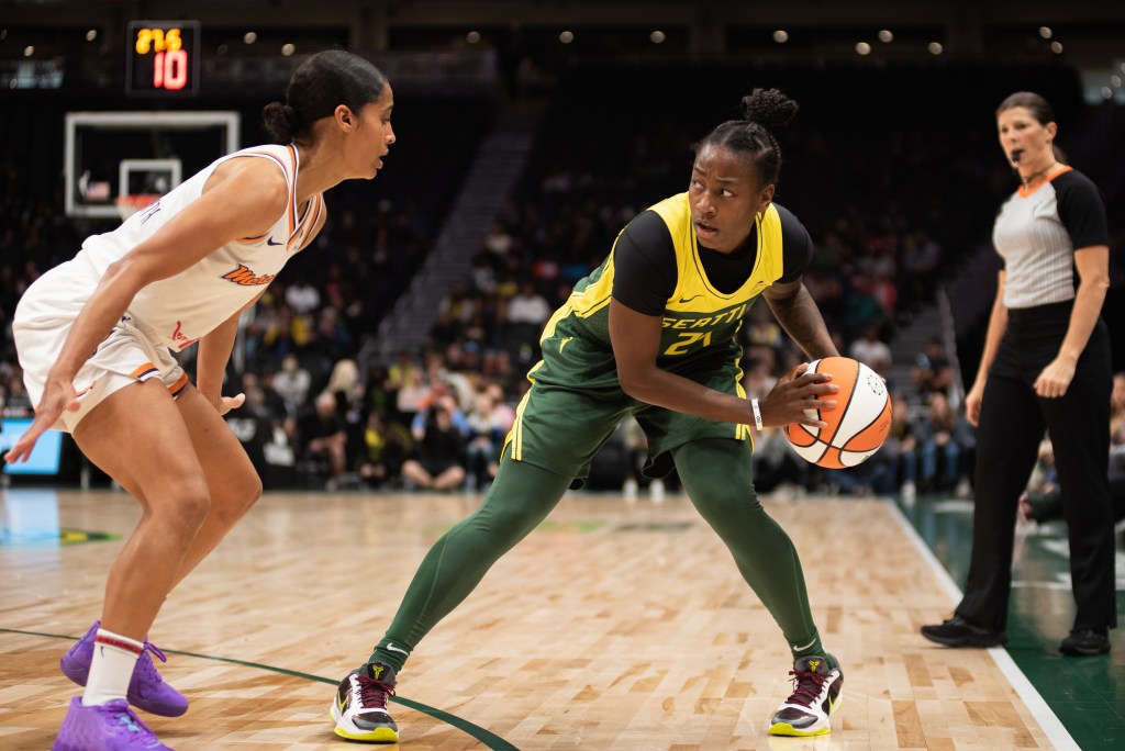 Seattle Storm combo guard Jewell Loyd in an exaggerated triple-threat stance, scanning the court, while being guarded by Phoenix Mercury combo guard Skylar Diggins-Smith