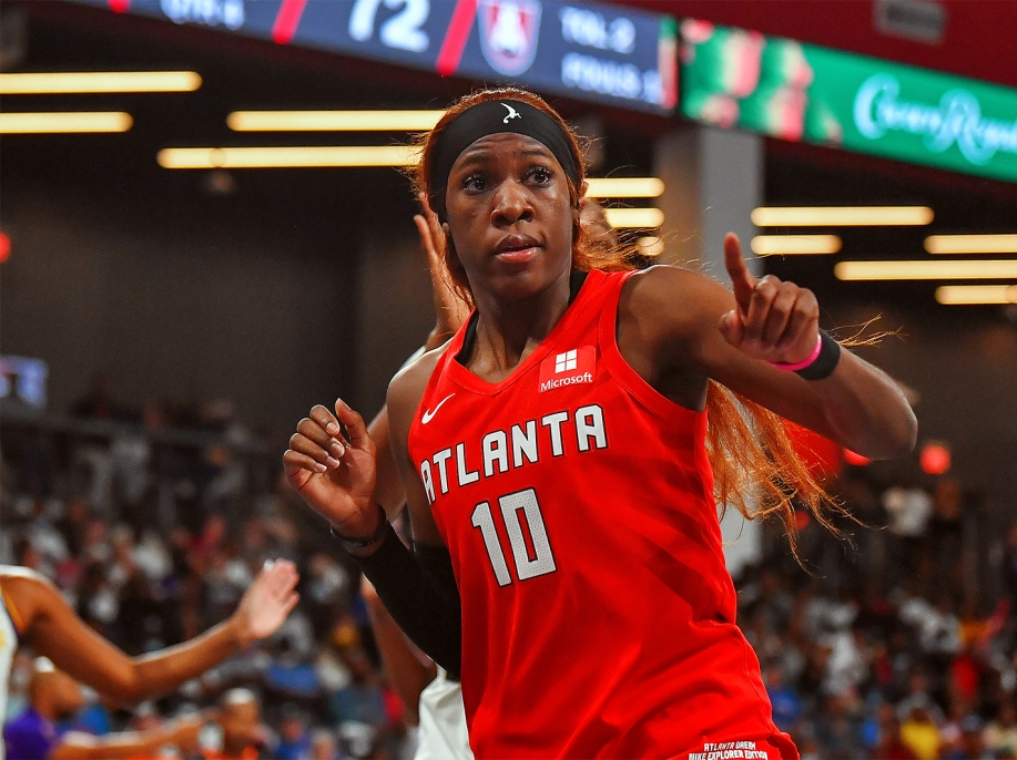 Rhyne Howard points at the sideline while running down the court