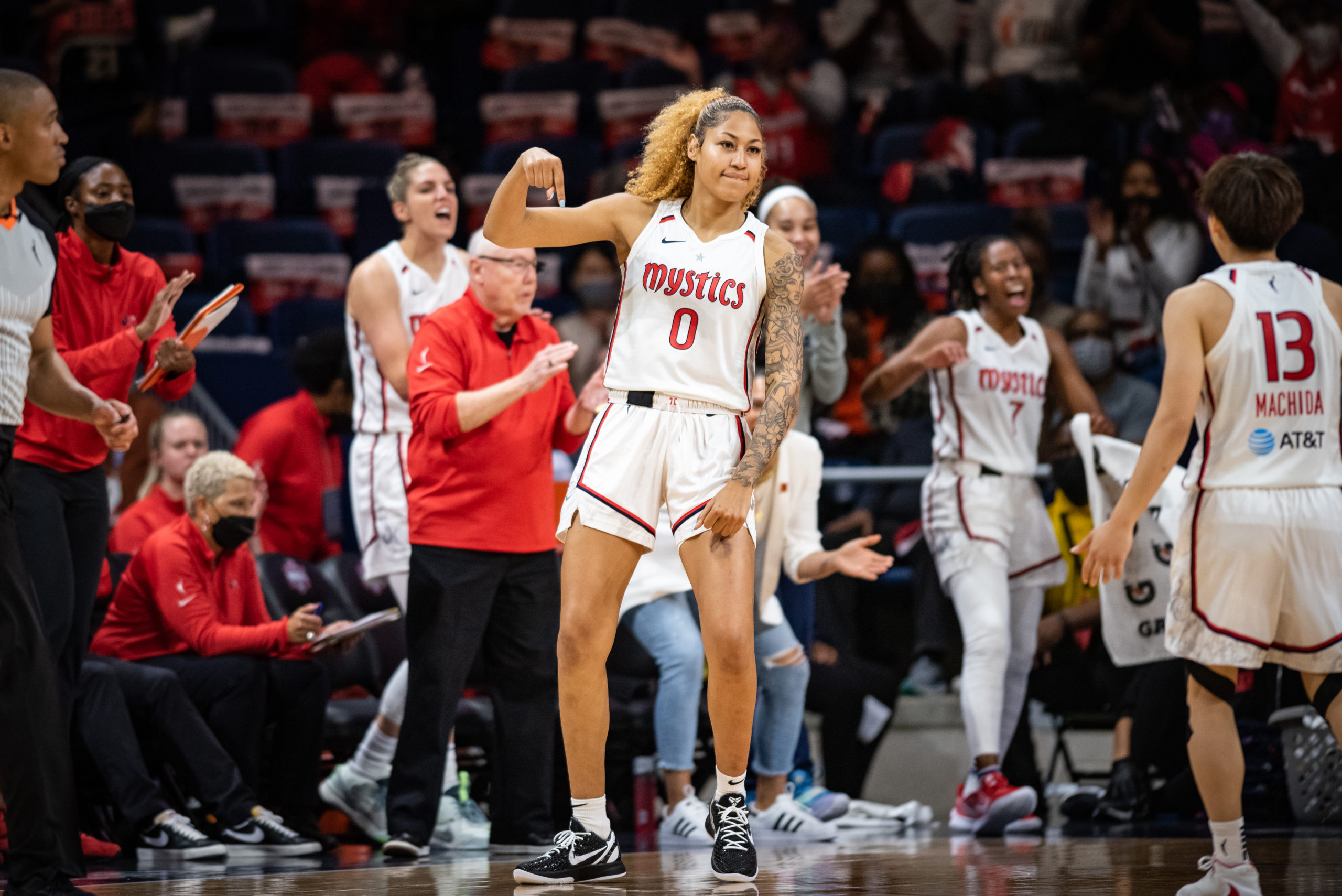 Shakira Austin celebrates on the court, while other Mystics claps and cheer in the background