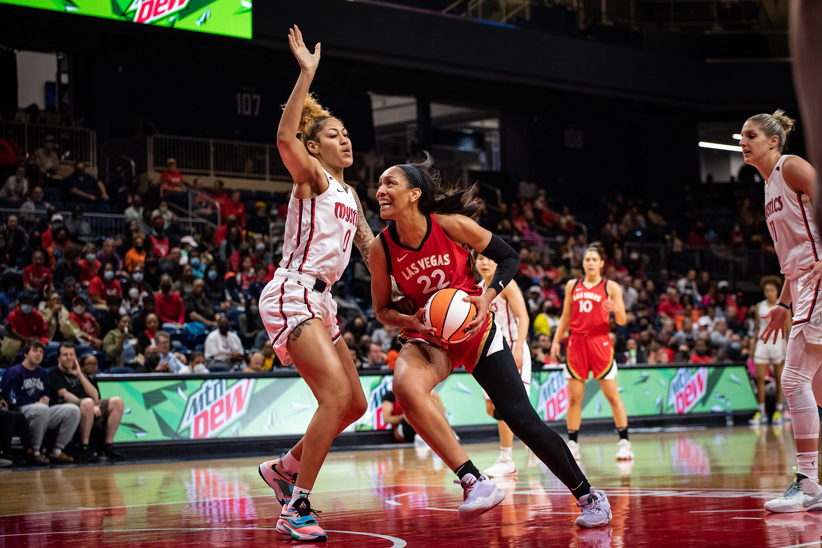 Las Vegas Aces center A'ja Wilson pushes off one foot to drive through Washington Mystics center Shakira Austn deep in the paint