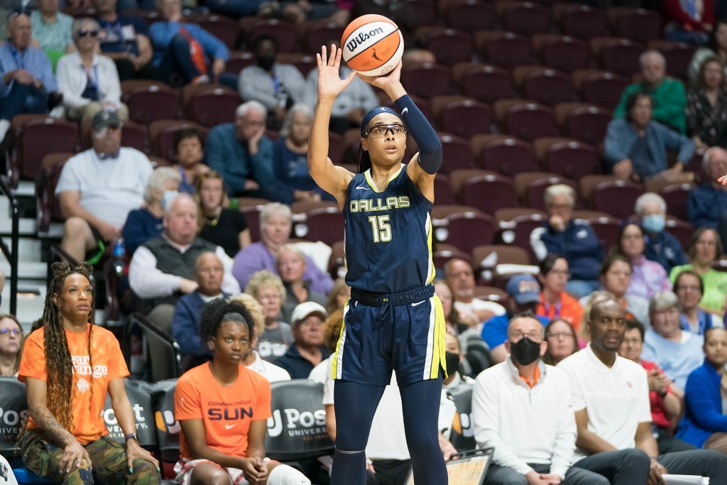 Dallas Wings wing Allisha Gray holds the ball above her head as she shoots a three-pointer