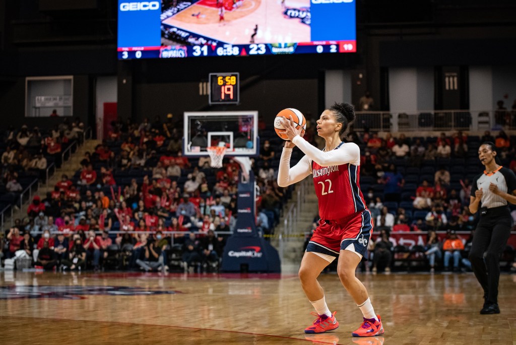 Washington Mystics off-ball guard Alysha Clark stands at the slot, holding the ball above her shoulder while crouching, as she readies to shoot a three