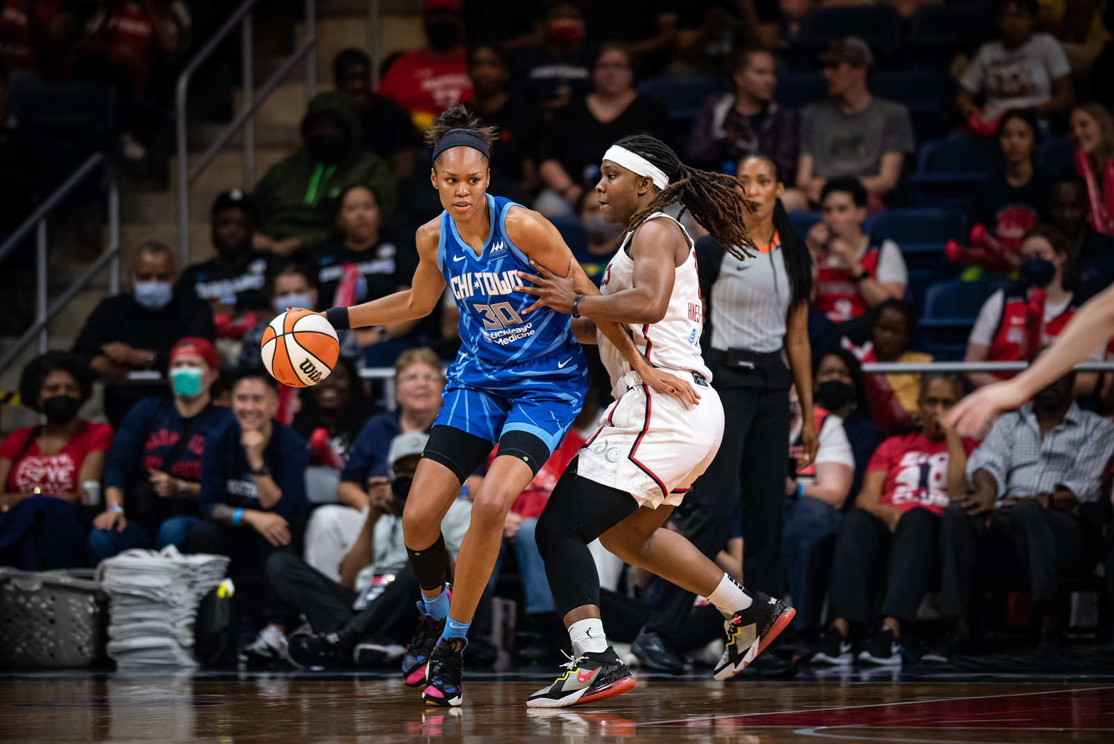 Chicago sky big Azurá Stevens dribbles while posting-up Washington Mystics big Myisha Hines-Allen, as Stevens puts a hand on Hines-Allen's hip and starts to spin around her