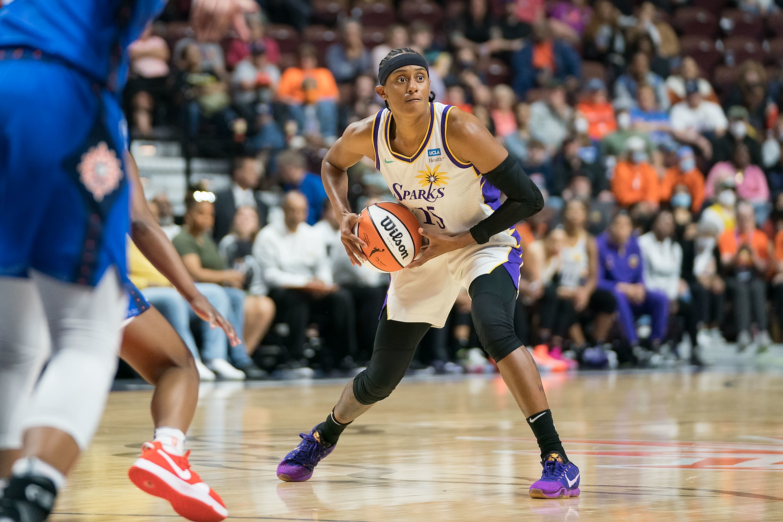 LA Sparks off-ball guard Brittney Sykes pulls the ball towards her stomach with both arms in preparation to pass
