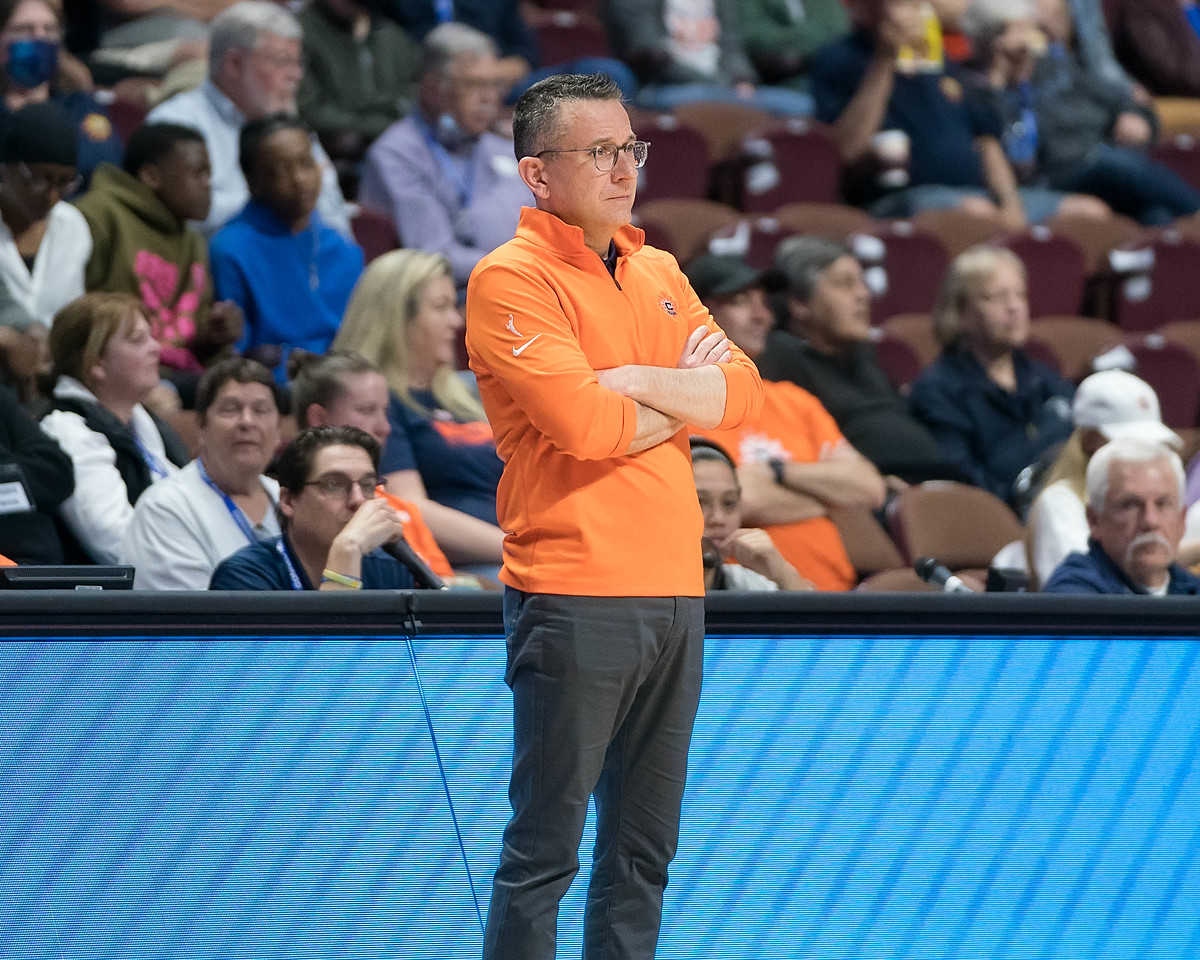 Connecticut Sun head coach Curt Miller stands in front of the scorer's table, looking out towards the court, with his arms crossed