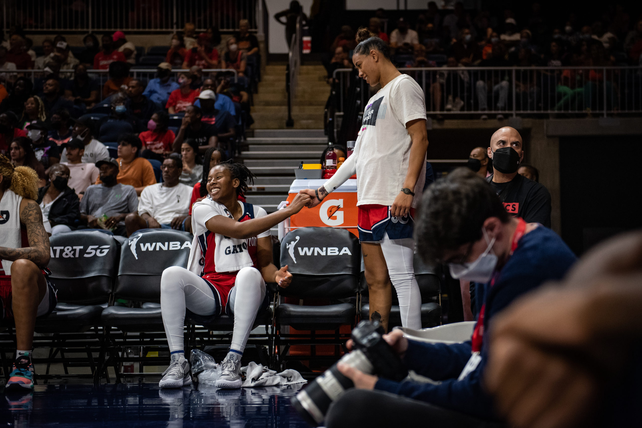 Washington Mystics guards Ariel Atkins (left) and Natasha Cloud celebrate on the bench during a game against the Atlanta Dream on June 28, 2022. (Photo credit: Domenic Allegra)
