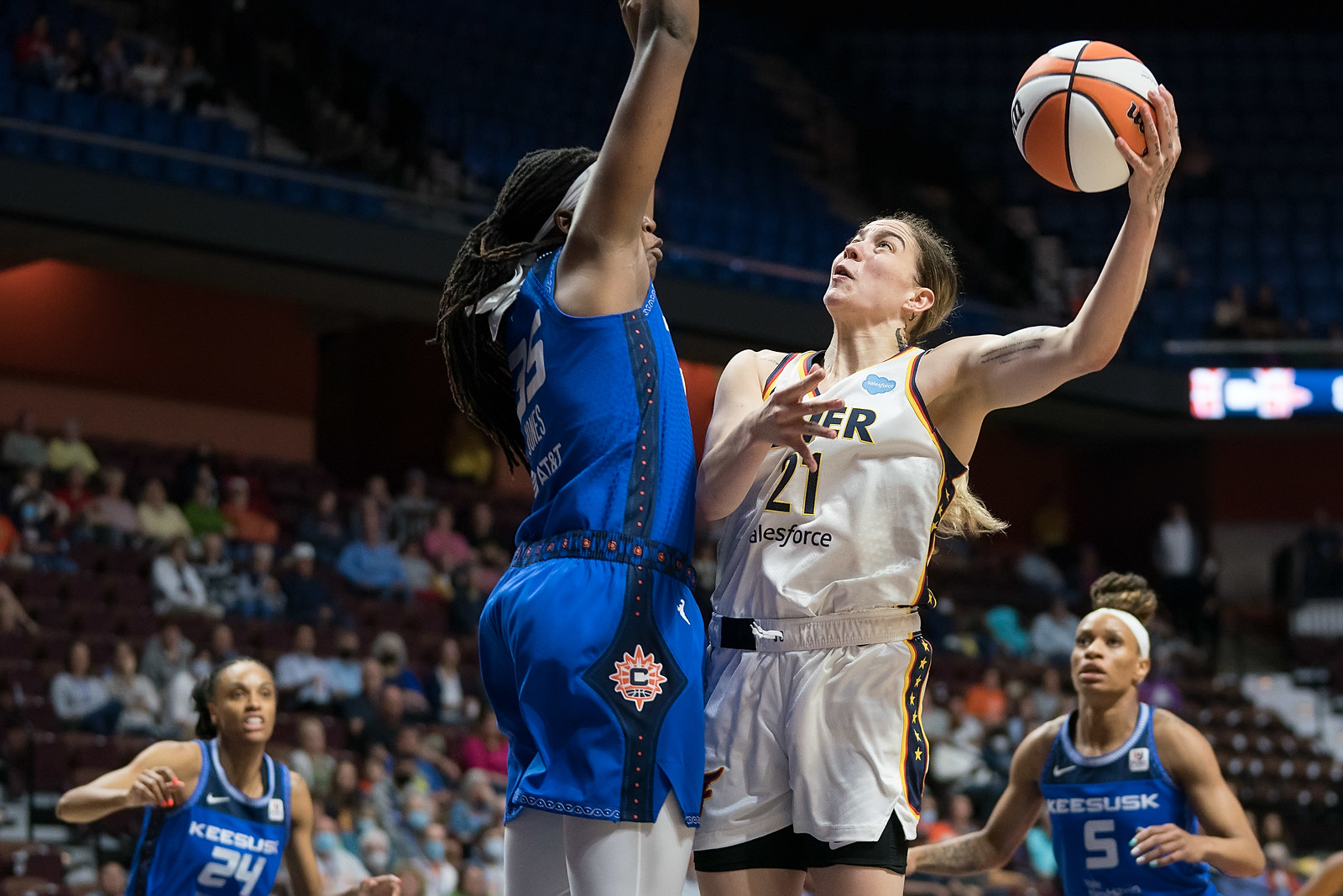 Indiana Fever combo forward Emily Engstler releases a left-handed hook shot as Jonquel Jones raises her arms up to block the shot in front of Engstler