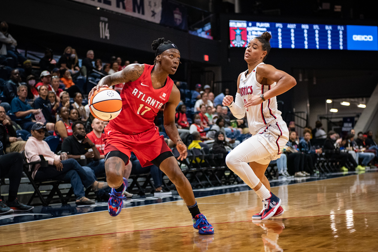 Atlanta Dream combo guard Erica Wheeler pushes off her right leg as she attempts a step-back move on Washington Mystics point guard Natasha Cloud, as Cloud attempts to catch up