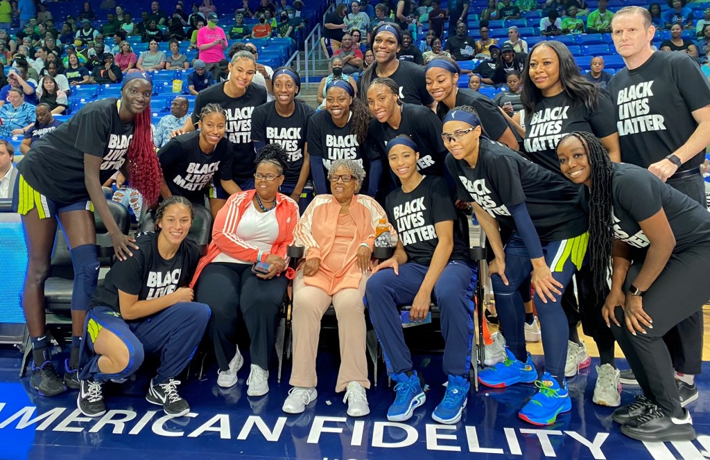 The Dallas Wings take a photo with Ms. Opal Lee - the "grandmother of Juneteenth" - before their game against the Seattle Storm on June 12, 2022. (Photo credit: Arie Graham)