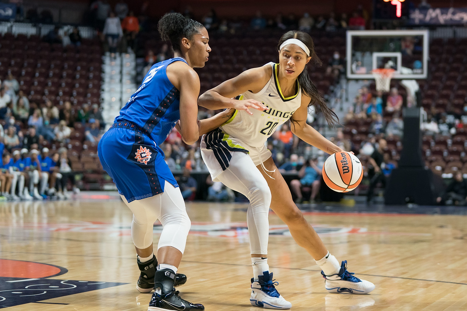 Dallas Wings big Isabelle Harrison dribbles as she post-up Connecticut Sun big Alyssa Thomas from the free-throw line extended