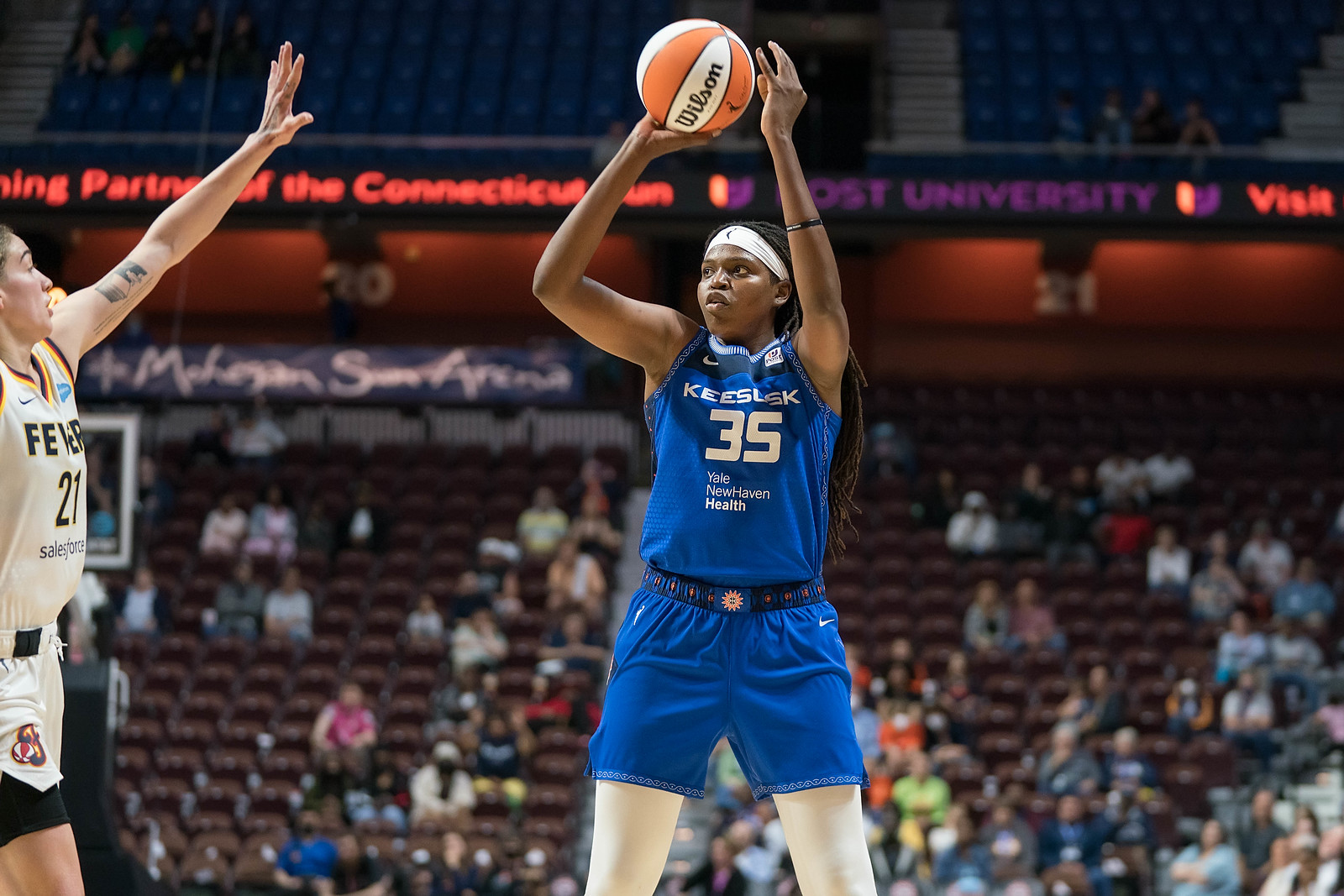 Connecticut Sun big wing Jonquel Jones holds the ball above her her as she begins shooting a jump shot