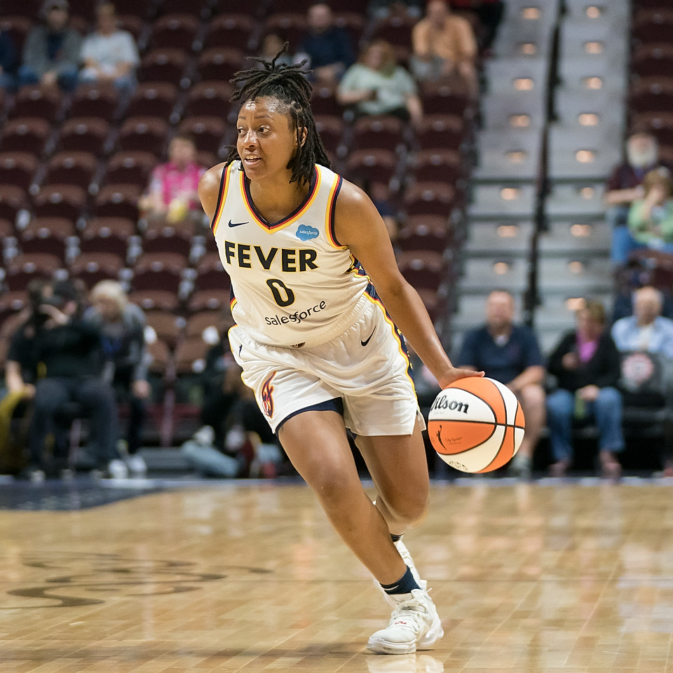 Indiana Fever combo guard Kelsey Mitchell dribbles low to the ground while advancing up the court