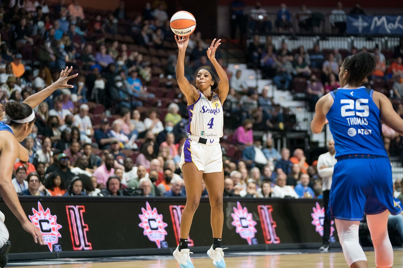 Los Angeles Sparks off-ball guard Lexie Brown releases a long jumper off fingertips, as two Connecticut Sun defenders watch on from a distance too far away to contest