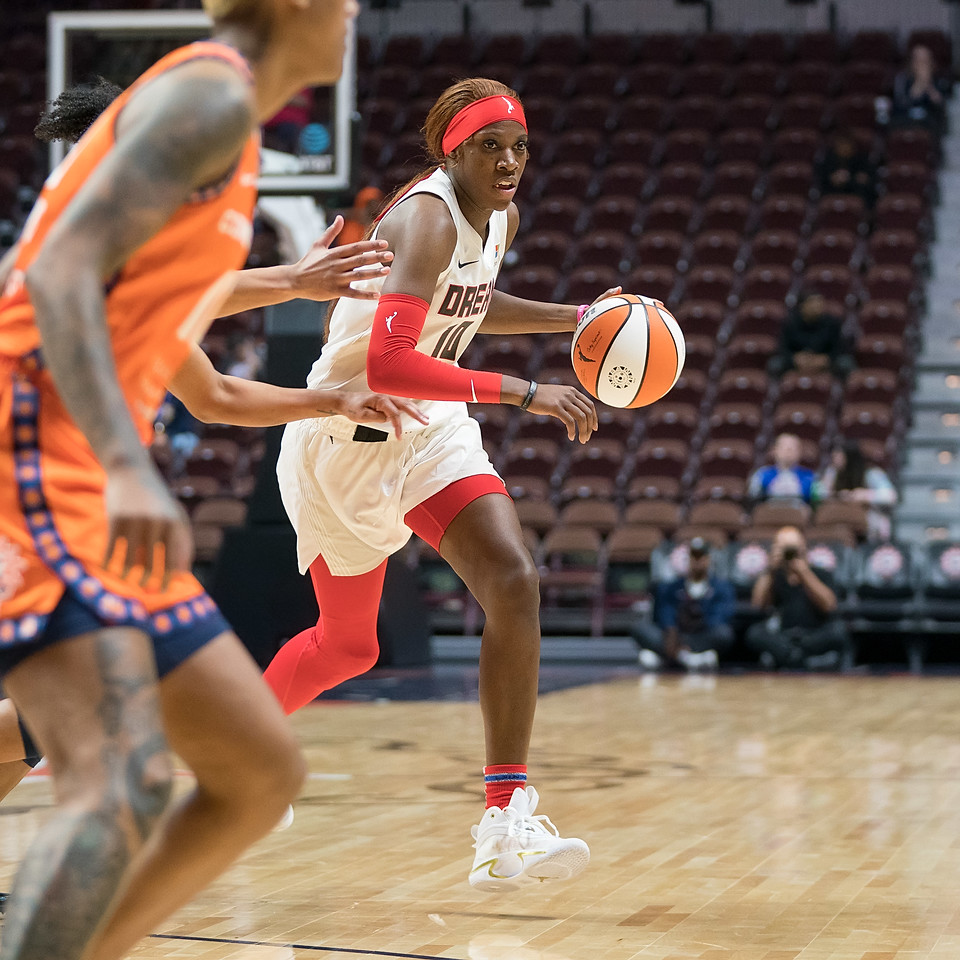 Atlanta Dream wing Rhyne Howard dribbles from the key around the arc as she looks towards the corner, while Connecticut Sun defenders stand upcourt of her in defensive stances