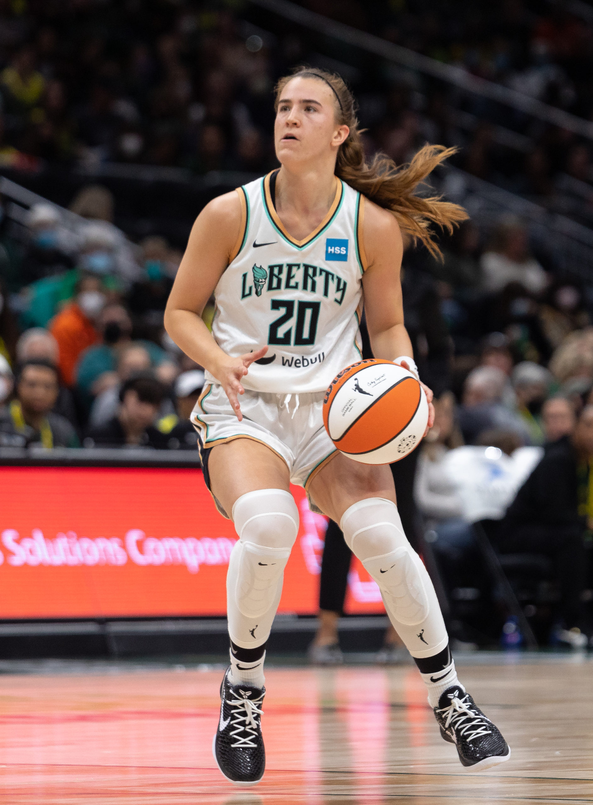 New York Liberty point guard Sabrina Ionescu looks up towards the rim, as she prepares to land on both feet and collect the ball to shoot, just inside the top of the arc